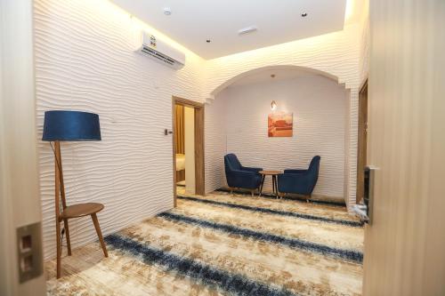 a hallway with a table and two blue chairs at فندق المدينة القديمة Old Town Hotel in Nizwa