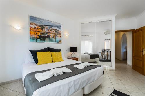 a bedroom with a large bed with yellow pillows at Quinta de São Roque by Algarve Golden Properties in Lagos
