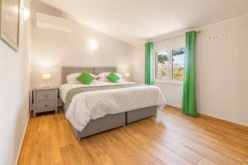 a bedroom with a large bed with green curtains at Casa Dean by Algarve Golden Properties in Lagos