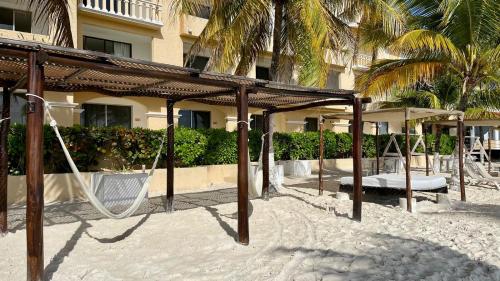 an empty swing set in the sand near a building at Tropical apartment in Cancún