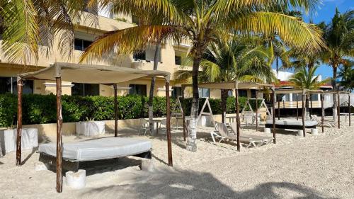 a resort with chairs and umbrellas on the beach at Tropical apartment in Cancún