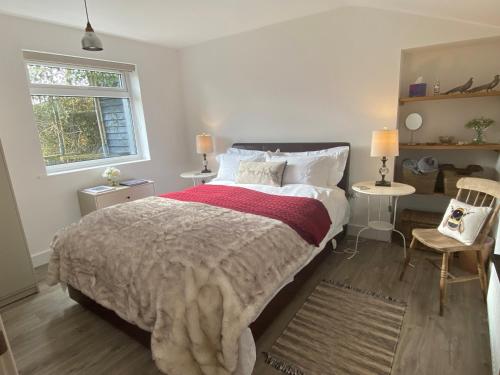 a bedroom with a large bed and a window at The Cottage at Churchill Farm in Mosterton