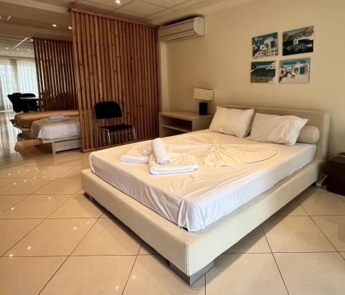 a bedroom with a large bed with towels on it at Hector Apartment Airport by Airstay in Spata