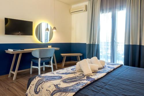 a bedroom with a bed and a desk and a mirror at Asteris Village in Gerakini