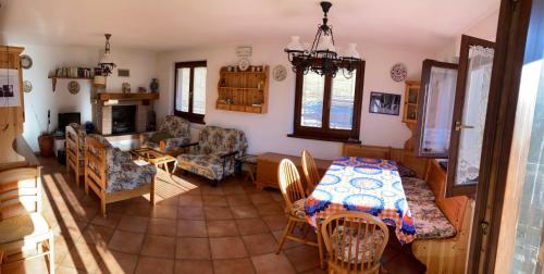 eine Küche und ein Wohnzimmer mit einem Tisch und Stühlen in der Unterkunft Casa vacanze Ravascletto in Ravascletto