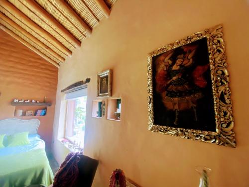 a bedroom with a painting on the wall at Finca La Candelaria in Maimará