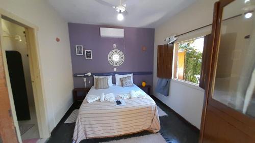 a bedroom with a bed with a purple wall at Pousada Catavento in Arraial d'Ajuda