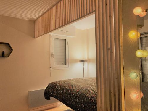 a bedroom with a bed and a mirror at Studio proche plage balcon et parking in Deauville