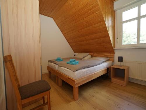 Landferienhof Garbert في Wilsum: غرفة نوم بسرير وكرسي في غرفة