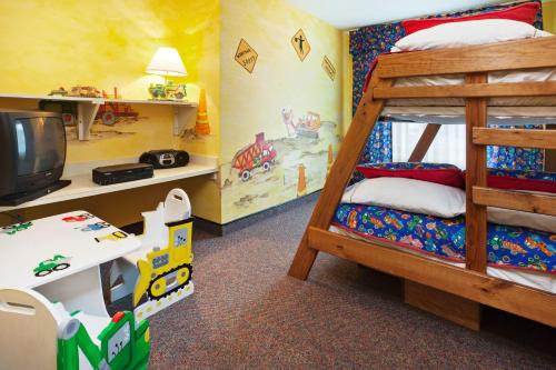 a bedroom with two bunk beds and a tv at Holiday Inn Express Hotel & Suites Corbin by IHG in Corbin
