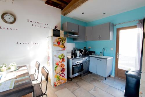 a kitchen with blue walls and a table and a sink at Ateliers, Terrasse - Parking - Clim in Arles