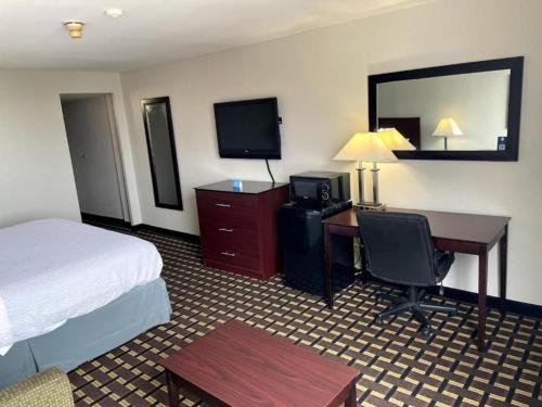 a hotel room with a bed and a desk with a computer at Days Inn by Wyndham Fort Wright Cincinnati Area in Fort Wright