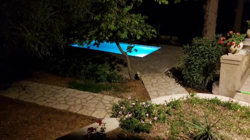 a blue bench sitting in a garden at night at Villa Casale Settesoldi in Salemi