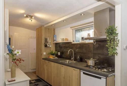 a kitchen with a sink and a counter top at Gezellig ingerichte blokhut op een rustig park! in Putten