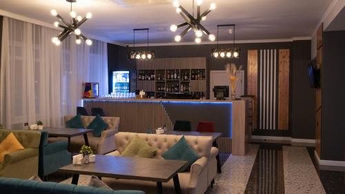 um restaurante com sofás e mesas e um bar em KRich Hotel Aktobe em Aqtöbe