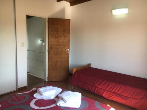 1 dormitorio con cama roja y colcha roja en Las Tortolas en Tandil