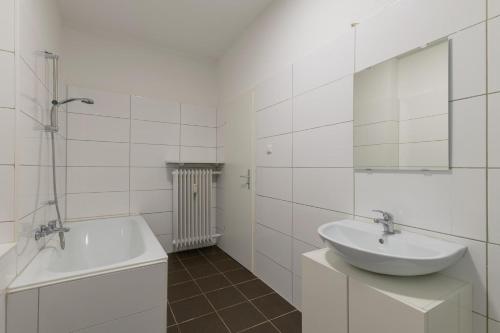a white bathroom with a sink and a bath tub at T&K Apartments-Duisburg 4 Zimmer Apartment in Duisburg