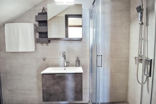 a bathroom with a sink and a shower at Noir Luxury Suite by CorfuEscapes in Corfu