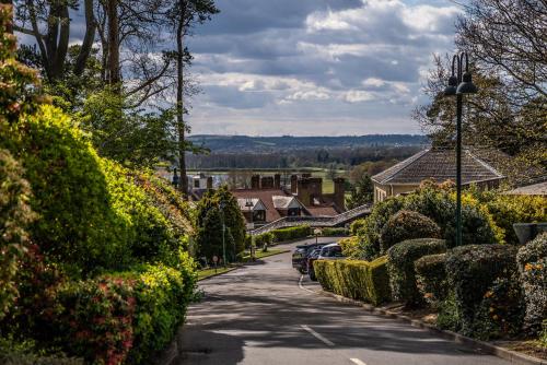 a street in a village with bushes and houses at Rutland Hall Hotel in Oakham