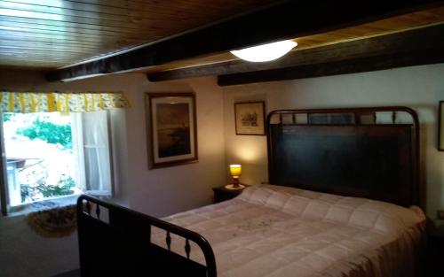 a bedroom with a bed and a window at Baita 7 Nani in Pievepelago