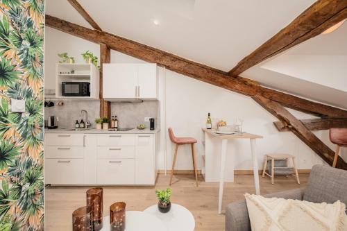 d'une cuisine et d'un salon avec des placards blancs et une table. dans l'établissement Chic studio dans le centre historique, à Toulouse