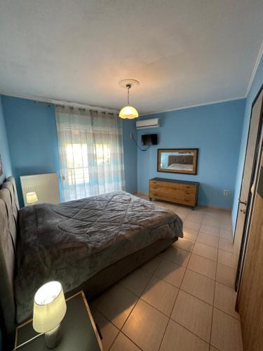 um quarto com uma cama grande e uma parede azul em Rania House em Limenas