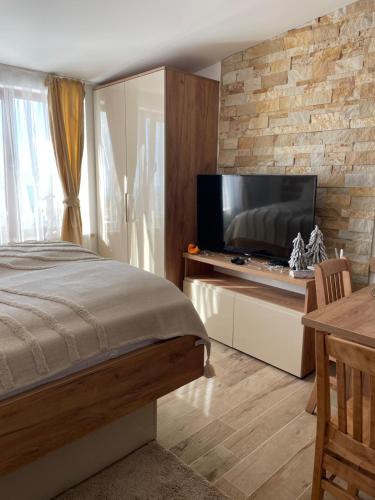 a bedroom with a bed and a flat screen tv at Apartmani NLUX and SPA in Kopaonik