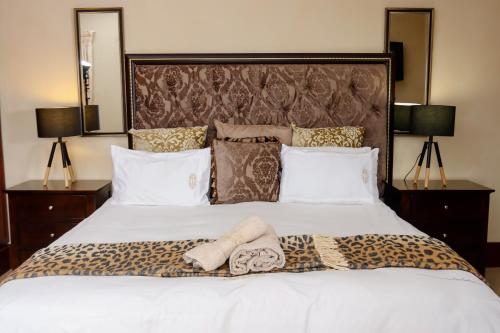 a bedroom with a large bed with two towels on it at TDM's Boutique Guest House in Pretoria