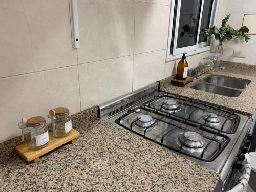 encimera de cocina con fogones y fregadero en Depto confortable en calle Bicentenario en Salta