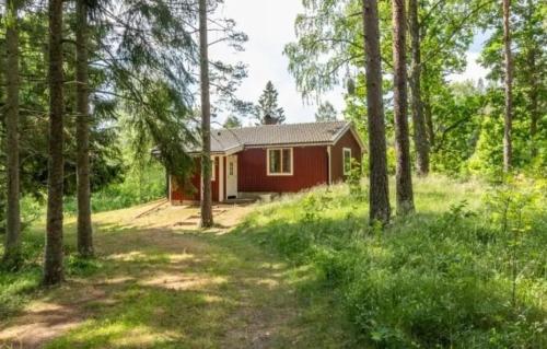 uma cabana vermelha no meio de uma floresta em Björktorpet em Linneryd