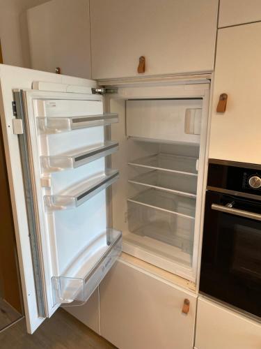an empty refrigerator with its door open in a kitchen at Appartement Am Waldweg in Achern