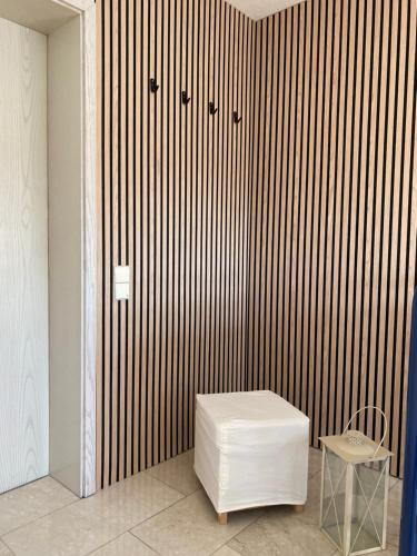 a room with a white stool and a wooden wall at Appartement Am Waldweg in Achern