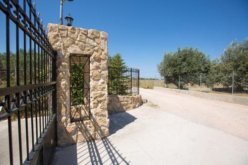 a black fence with a stone pillar next to a road at Serenity Sea-View Home in Afantou