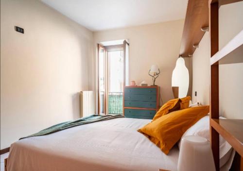 1 dormitorio con 1 cama con cómoda azul y ventana en LAGO D'ISEO - Ampio alloggio in centro storico en Pisogne