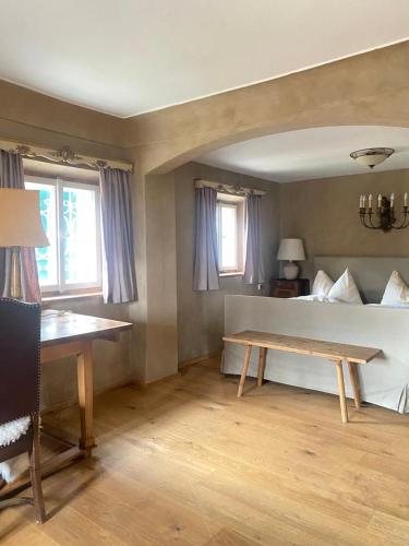 a room with a bed and a table and windows at (A) Privatzimmer in 400 Jahre alten Bauernhaus in Niederalm