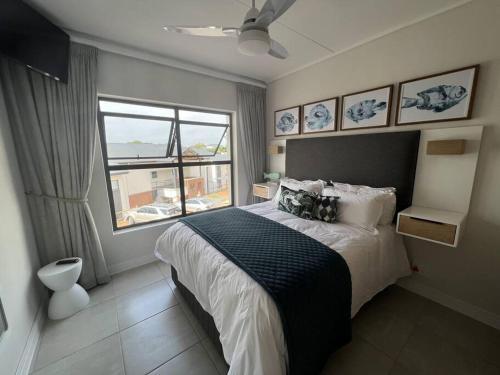 a bedroom with a large bed and a window at 427 Ballito Hills - Lovely 3 bedroom apartment in Ballito