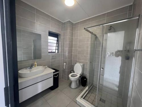 a bathroom with a toilet and a sink and a shower at 427 Ballito Hills - Lovely 3 bedroom apartment in Ballito