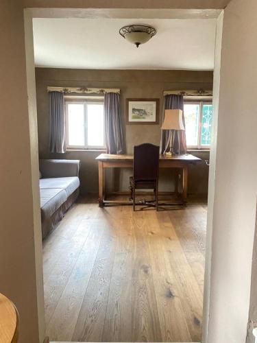 a bedroom with a bed and a desk with a chair at (A) Privatzimmer in 400 Jahre alten Bauernhaus in Niederalm