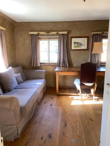 a living room with a couch and a desk at (A) Privatzimmer in 400 Jahre alten Bauernhaus in Niederalm