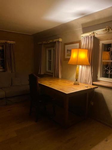 een bureau met een lamp in een kamer bij (A) Privatzimmer in 400 Jahre alten Bauernhaus in Niederalm