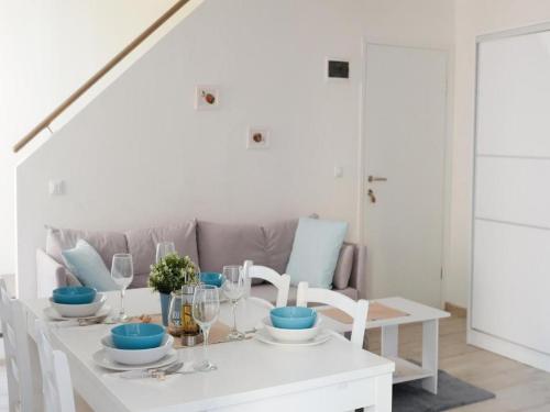 a white dining room with a white table and chairs at Apartments Blue Lavender in Cres