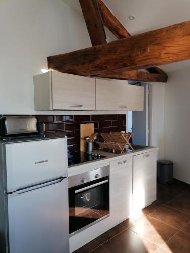 - une cuisine avec des appareils blancs et un mur en briques dans l'établissement Les Halles 3, à La Rochelle