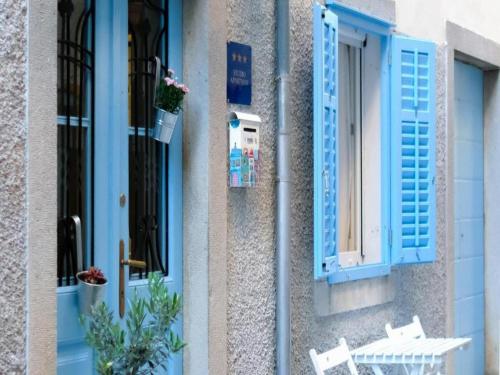 a building with blue shutters and a table and chairs at Apartments Blue Lavender in Cres