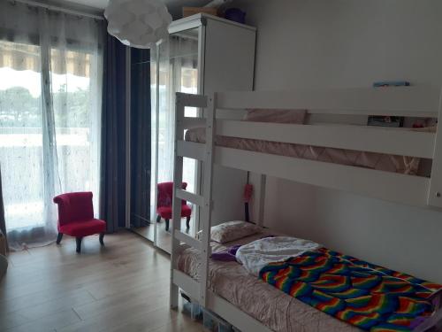 - une chambre avec des lits superposés et un fauteuil rouge dans l'établissement Appartement 3P avec garage proche aéroport, tramway et avec toutes commodités!, à Nice