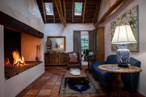 uma sala de estar com lareira e sofá em Taaibosch Collection em Stellenbosch