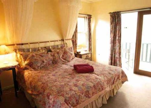 Un dormitorio con una cama con una maleta roja. en Mooltan House, en Hepburn Springs