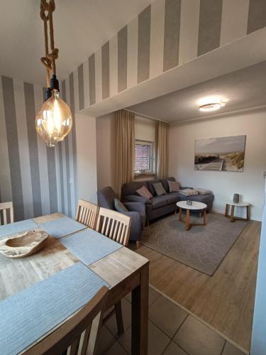 ein Wohnzimmer mit einem Tisch und einem Sofa in der Unterkunft Lütt Nest Föhr in Alkersum