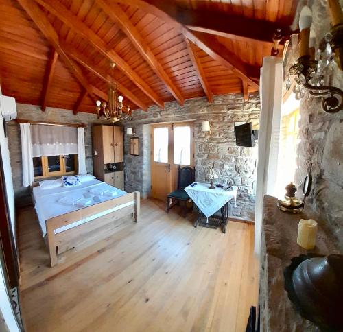 a bedroom with a bed and a stone wall at SARI KEÇİ TAŞ OTEL in Gokceada Town