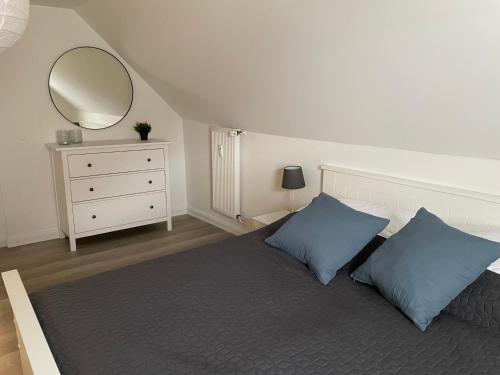 a bedroom with a bed with blue pillows and a mirror at Wohnungen mit direktem Meerblick in Laboe
