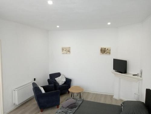 a living room with two chairs and a tv at Studio Slijterij Zandvoort in Zandvoort